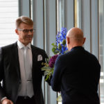 Rehtori Jukka Raiskinmäki ojentaa kukat taiteilija Jaakko Niemelälle.