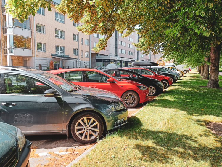 Autoja parkkeerattuna rivissä keskuspuiston lähellä.