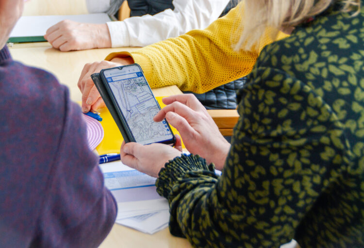 The workshop members are looking at a map on the phone.