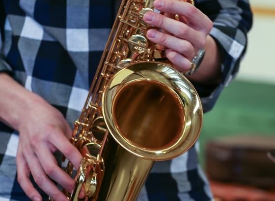 Saksofonin soittoa Rauman musiikkiopistossa, lähikuvassa saksofoni ja kädet.