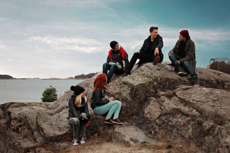 Viisi nuorta rantakallioilla.