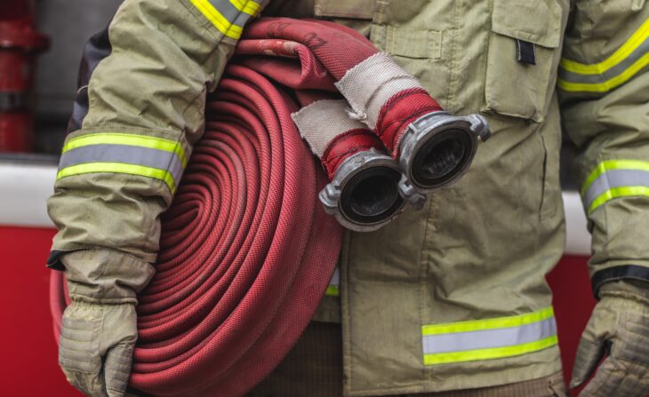 Firefighter carrying a hose.