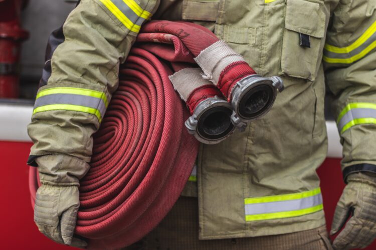 Firefighter carrying a hose.