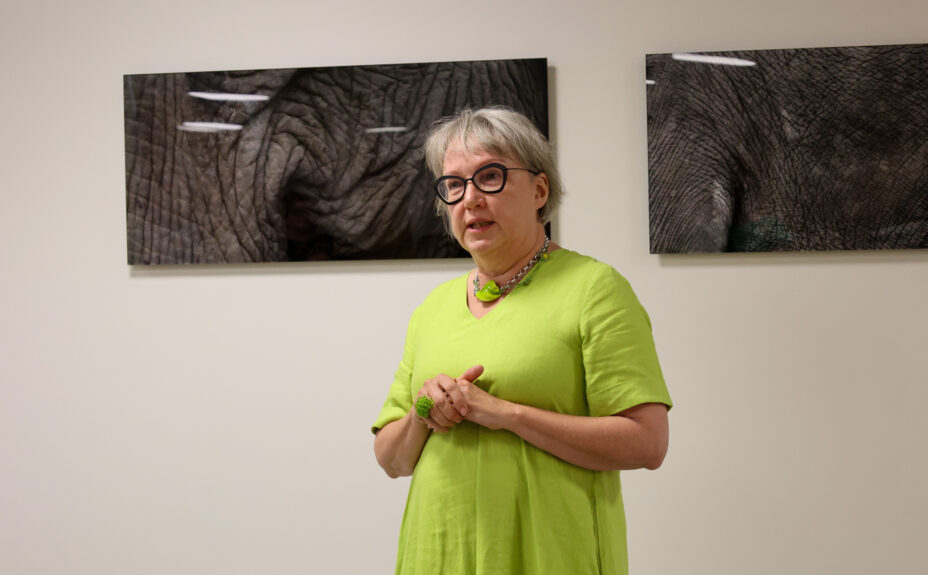 Taiteilija Päivi Setälä, taustalla Vahva ja herkkä -teos.