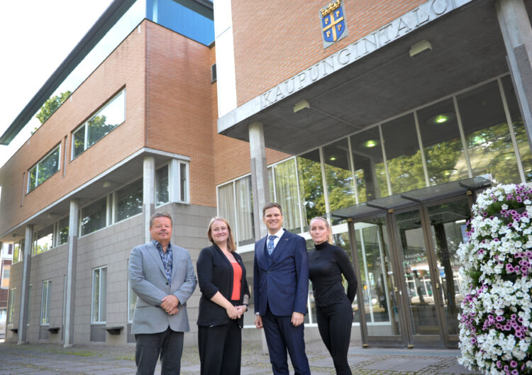 Sivistysvaliokunnan puheenjohtaja Reijo Ringbom, kaupunginhallituksen puheenjohtaja Heidi Hiljanen, kaupunginvaltuuston puheenjohtaja Otso Huuska ja teknisen valiokunnan puheenjohtaja Iida Lampi seisomassa Rauman kaupungintalon edessä.