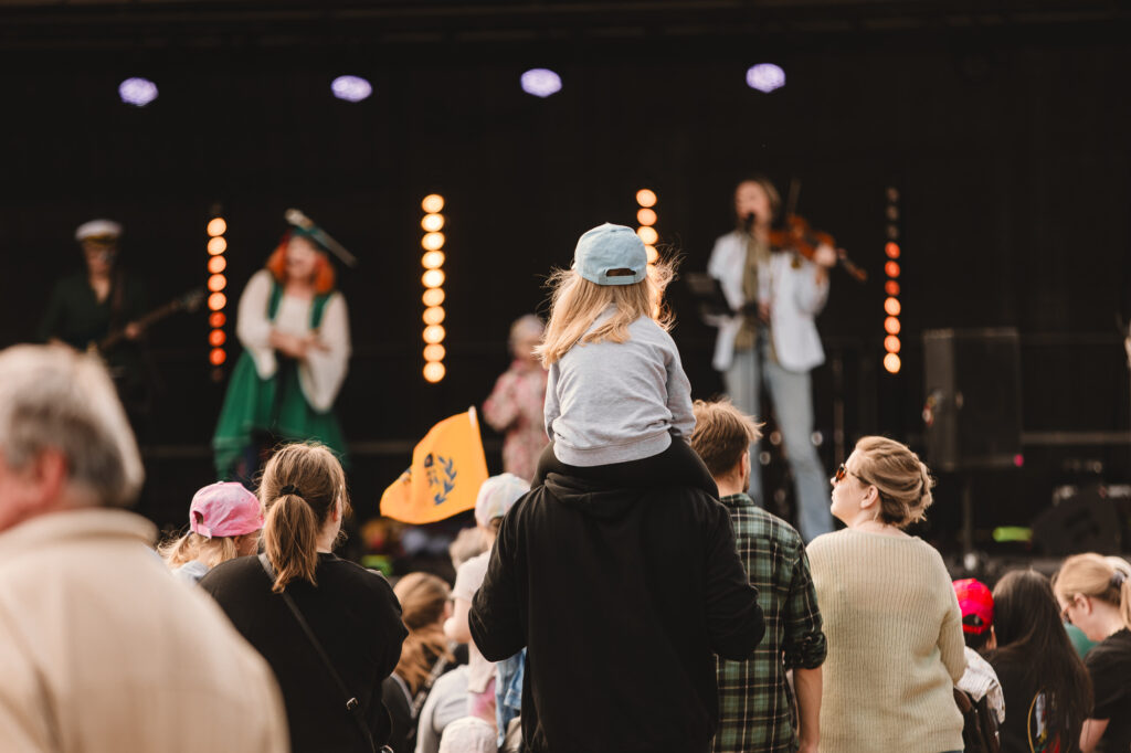 Tyttö istuu hartiolla Rauma-päivän torijuhlassa.