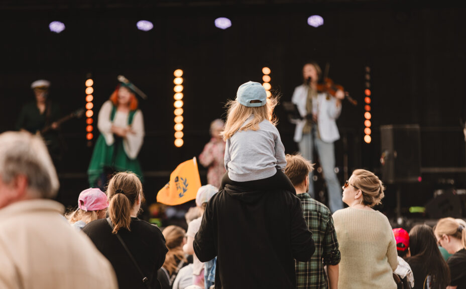 Tyttö istuu hartiolla Rauma-päivän torijuhlassa.