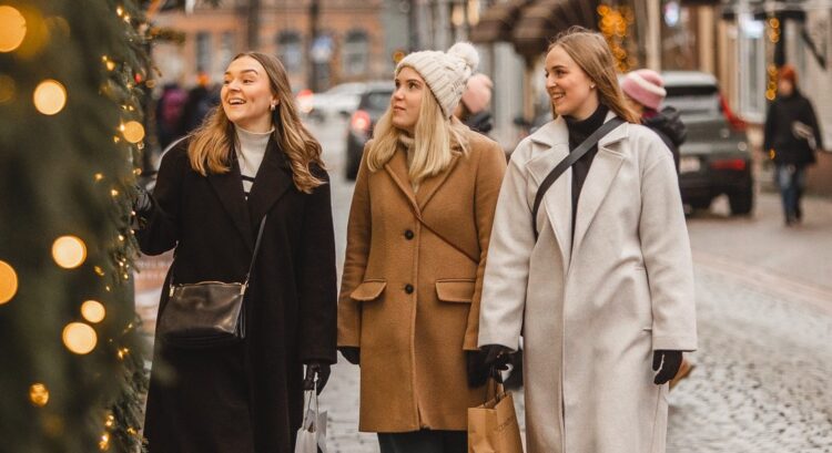 Kuva kolmesta hymyilevästä naisesta jouluisessa Vanhassa Raumassa.