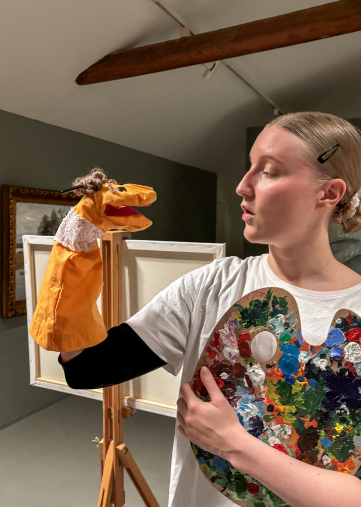 Esiintyjä katsoo käsinukkea Uskallusta sukassa -näytelmässä.