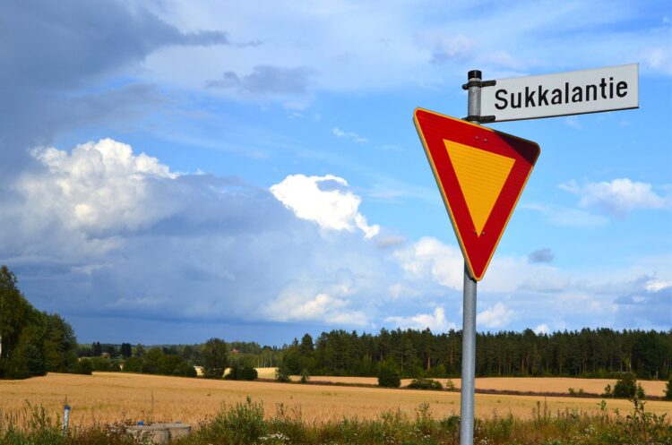 Maalaismaisemaa ja liikennemerkki.