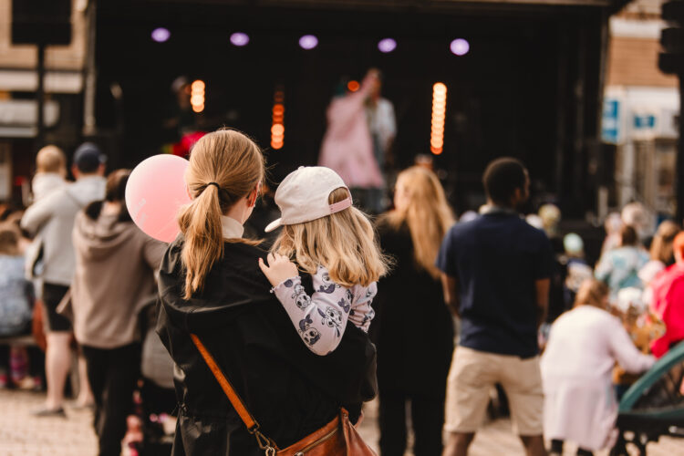 Nainen ja lapsi seuraamassa esitystä Rauman torilla.
