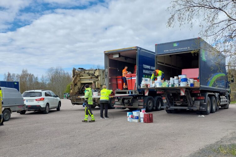 Kuvassa vaarallisen jätteen keräys -autoja ja Rauman seudun jätehuoltolaitoksen työntekijöitä nostamassa vaarallisia jätteitä autoihin.