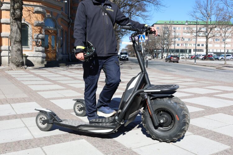 Kuvassa pysäköinnintarkastaja kolmipyöräisellä sähköpotkukelkalla.
