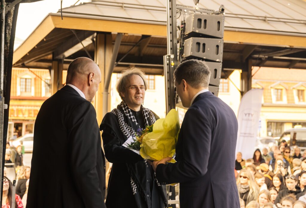 Elokuvaohjaaja Lauri-Marri Parppei Rauman torijuhlassa vastaanottamassa kukat lavalla.