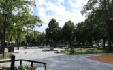 Photo of the renovated Rauma Central Park, featuring the Tasala Vilkk and Hakkri Iiro sculpture, newly paved walkways, and green trees.