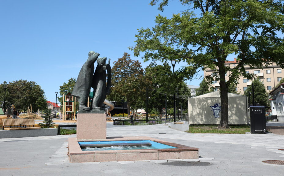 Photo of the renovated Rauma Central Park, featuring the Tasala Vilkk and Hakkri Iiro sculpture, newly paved walkways, and green trees.