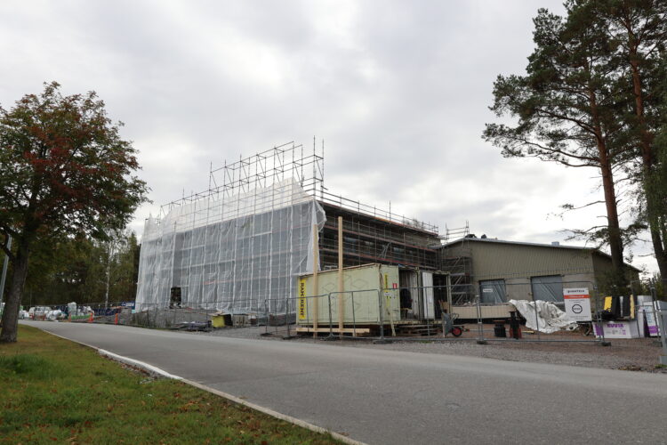 Exterior view of the Papinpelto Youth Centre and Youth Workshop building under construction. The entire two-part building is visible, with part of it still covered by a temporary weather protection structure.